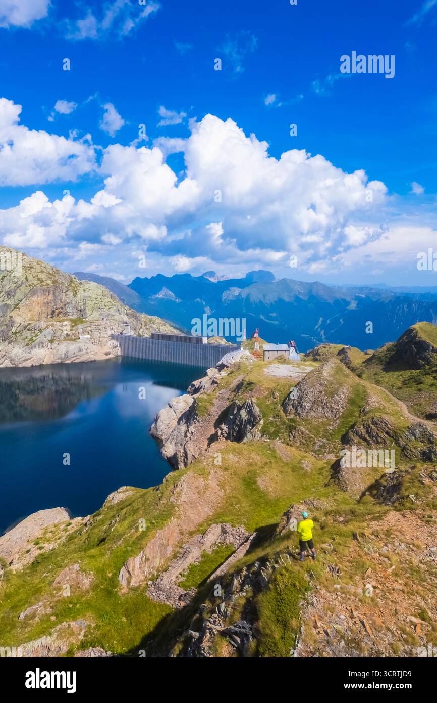 Aerial view of a person admiring Lago Nero during summer time. Valgoglio, Val Seriana, Bergamo district, Lombardy, Italy, Southern Europe. Stock Photo