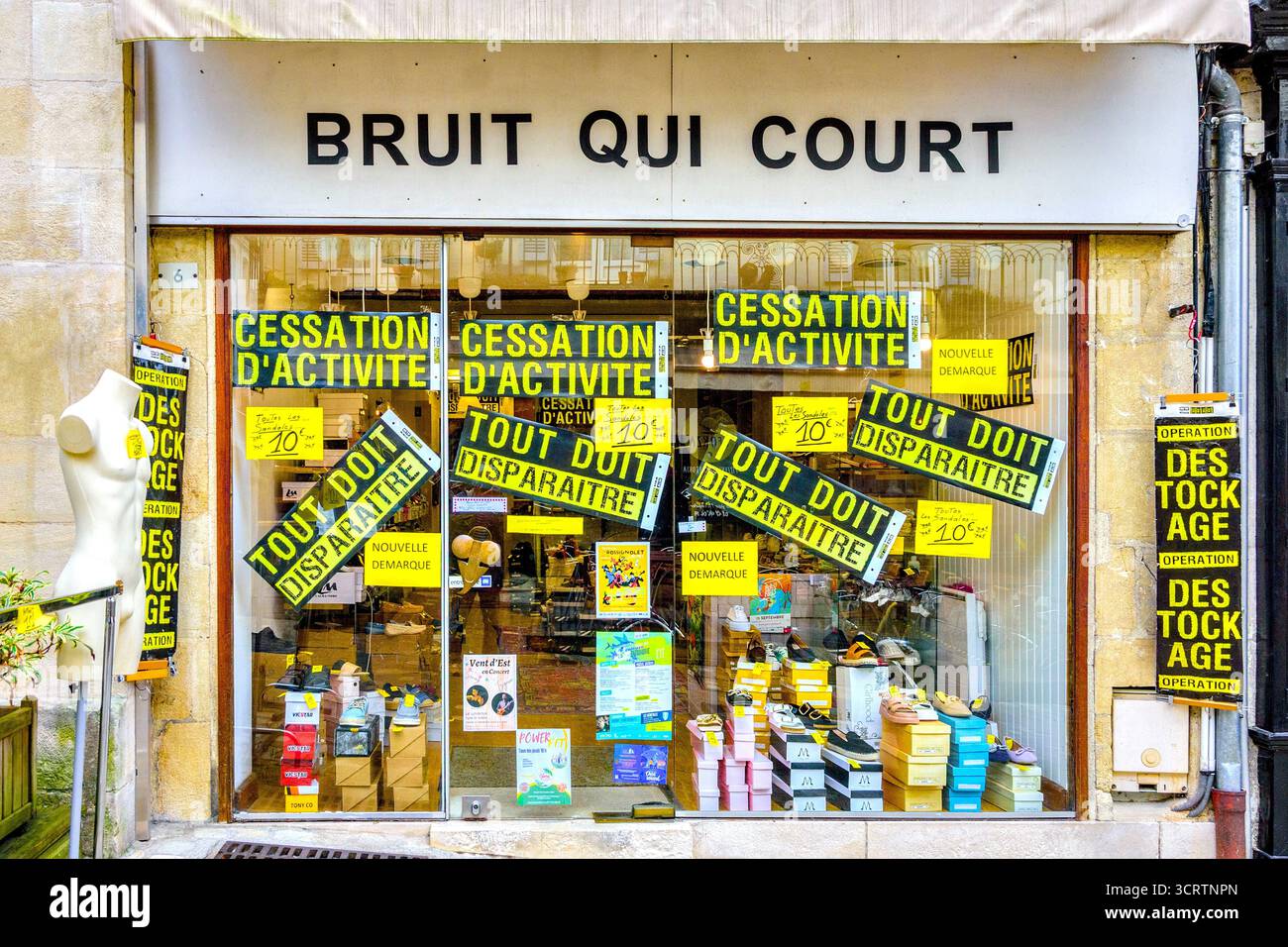 Shoe and footwear shop closing down with sale stickers on front window - Loches, Indre-et-Loire (37), France. Stock Photo