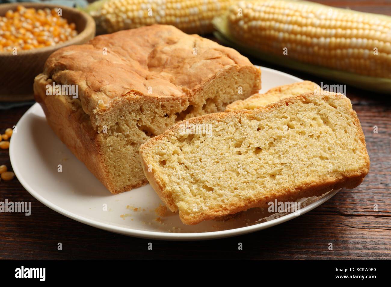 Freshly baked cornbread, cobs and seeds on wooden table, closeup Stock Photo