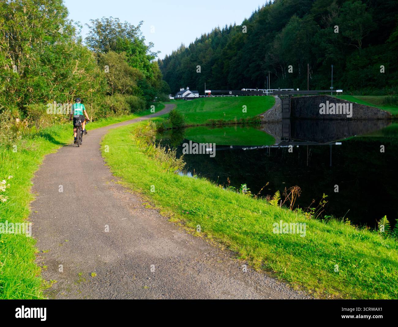 Cyclist on Caledonian Way next to Crinan canal, Argyll, Scotland Stock Photo
