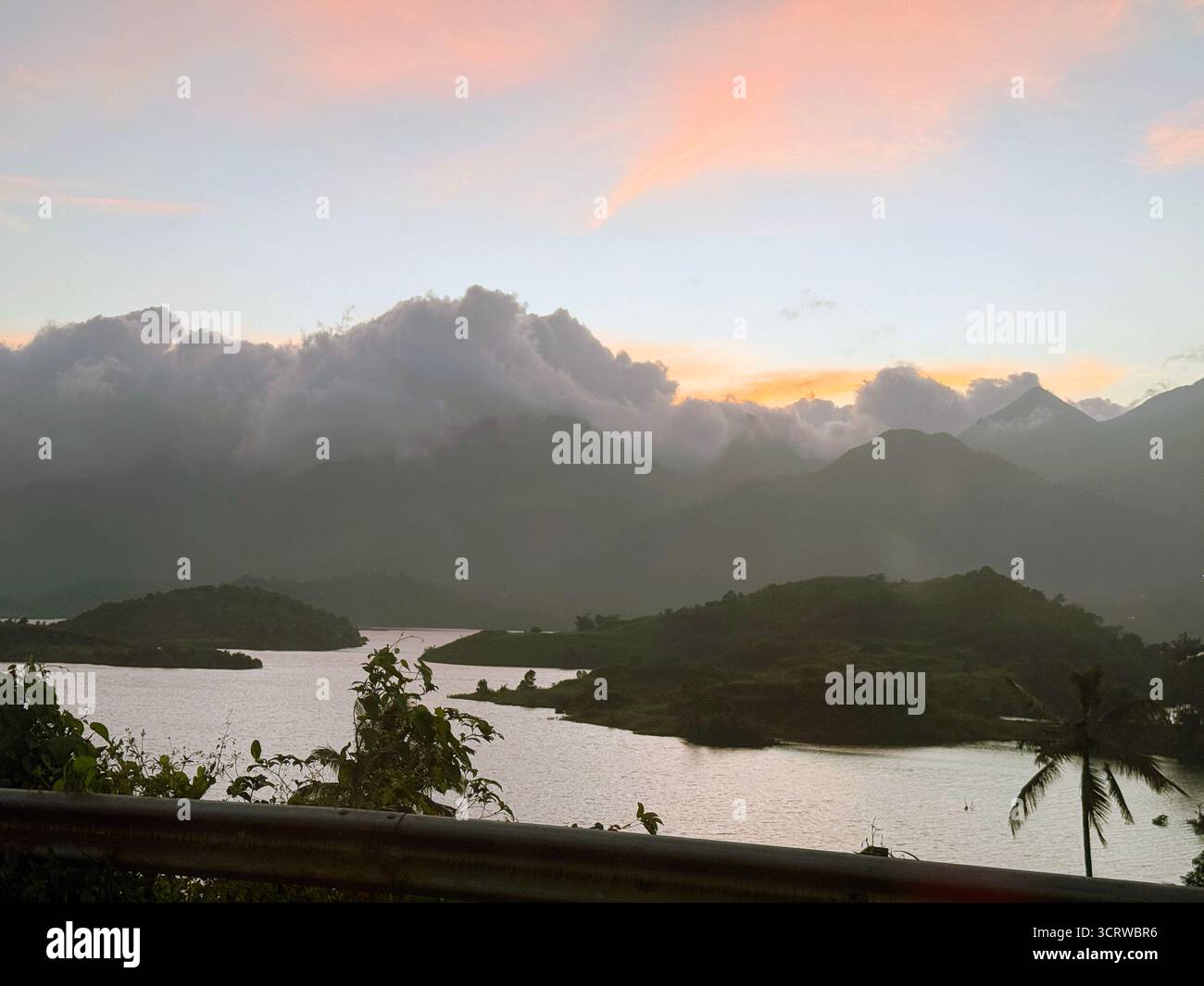 A hazy, golden goodbye from the sun painting the clouds over the water. Serene moments high above the landscape. - Smartphone Captured Stock Image