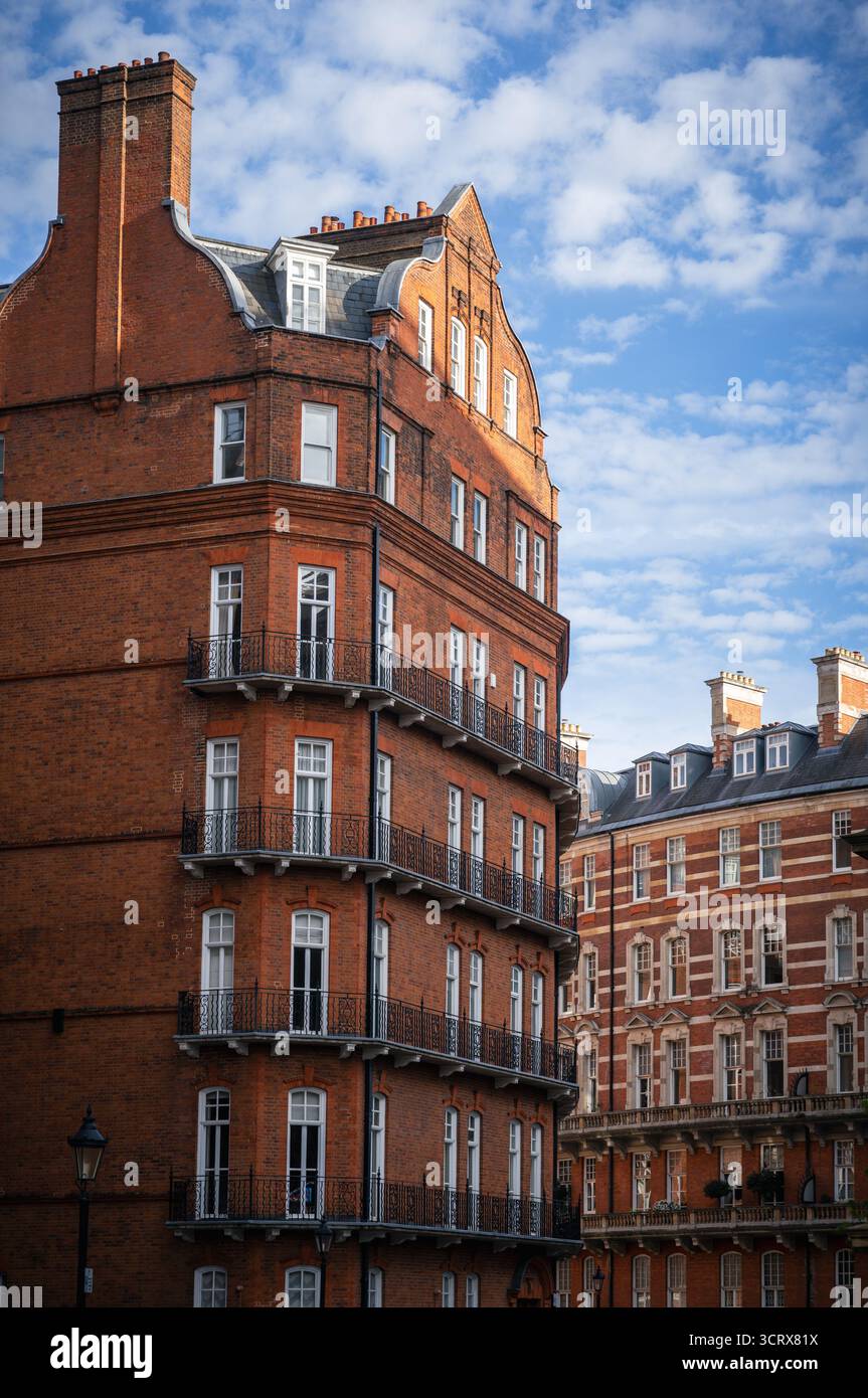View of Albert Hall Mansions, the red-brick residential building behind the Royal Albert Hall in London, captured in the late afternoon sunlight with Stock Photo