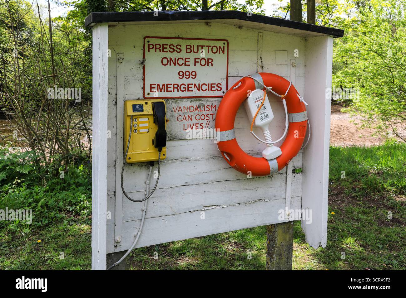 A life belt and emergency telephone next to the River Swale, Richmond, North Yorkshire, England, UK Stock Photo
