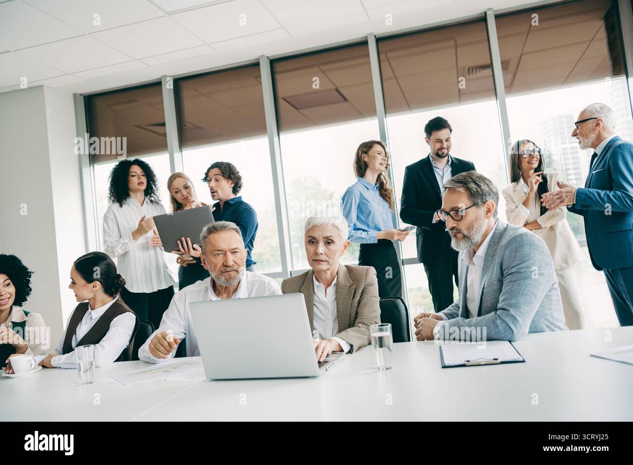 Collaborative office environment showcasing teamwork among diverse professionals communicating and collaborating Stock Photo