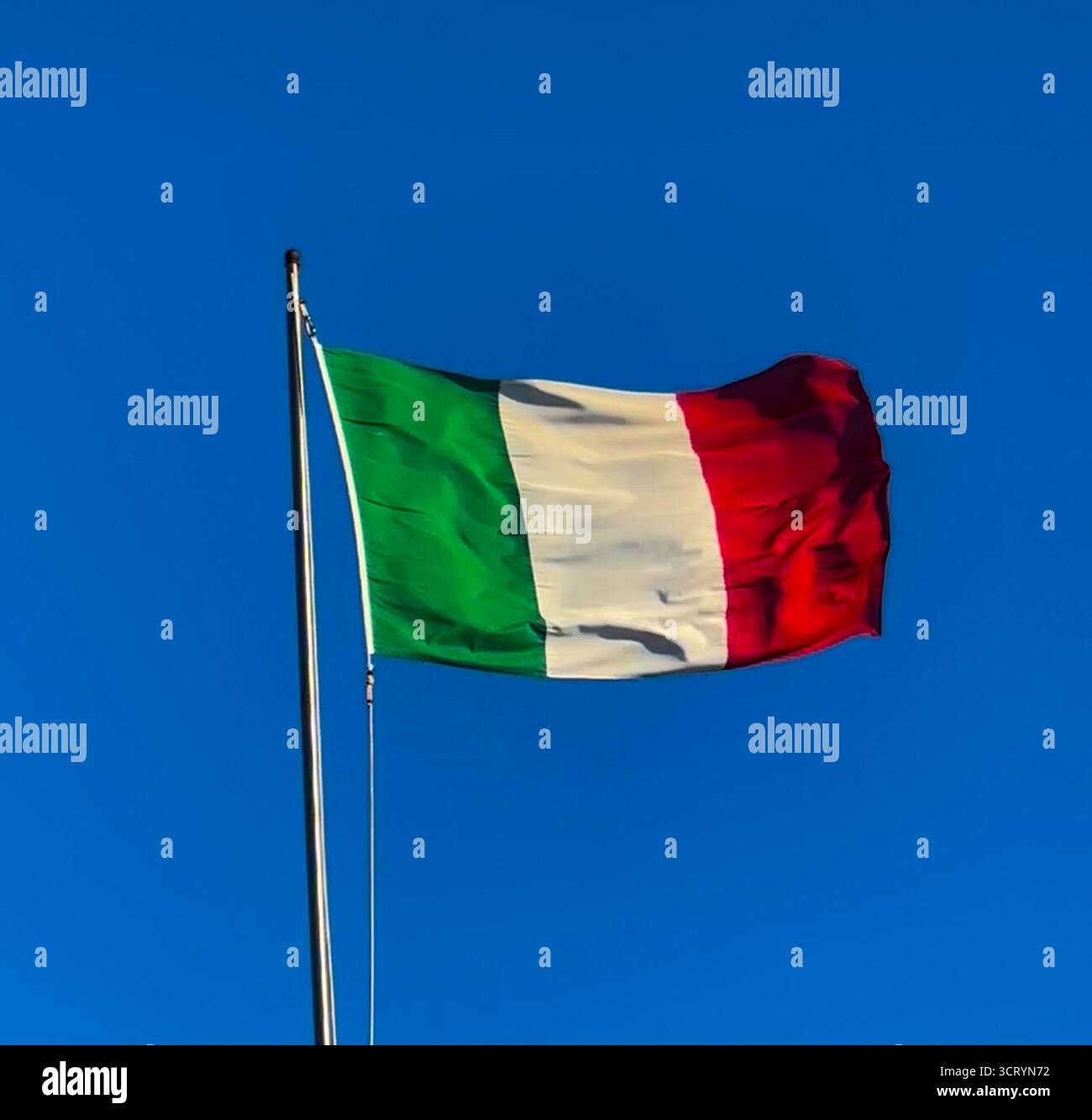 The Italian flag against a blue sky. - Smartphone Captured Stock Image