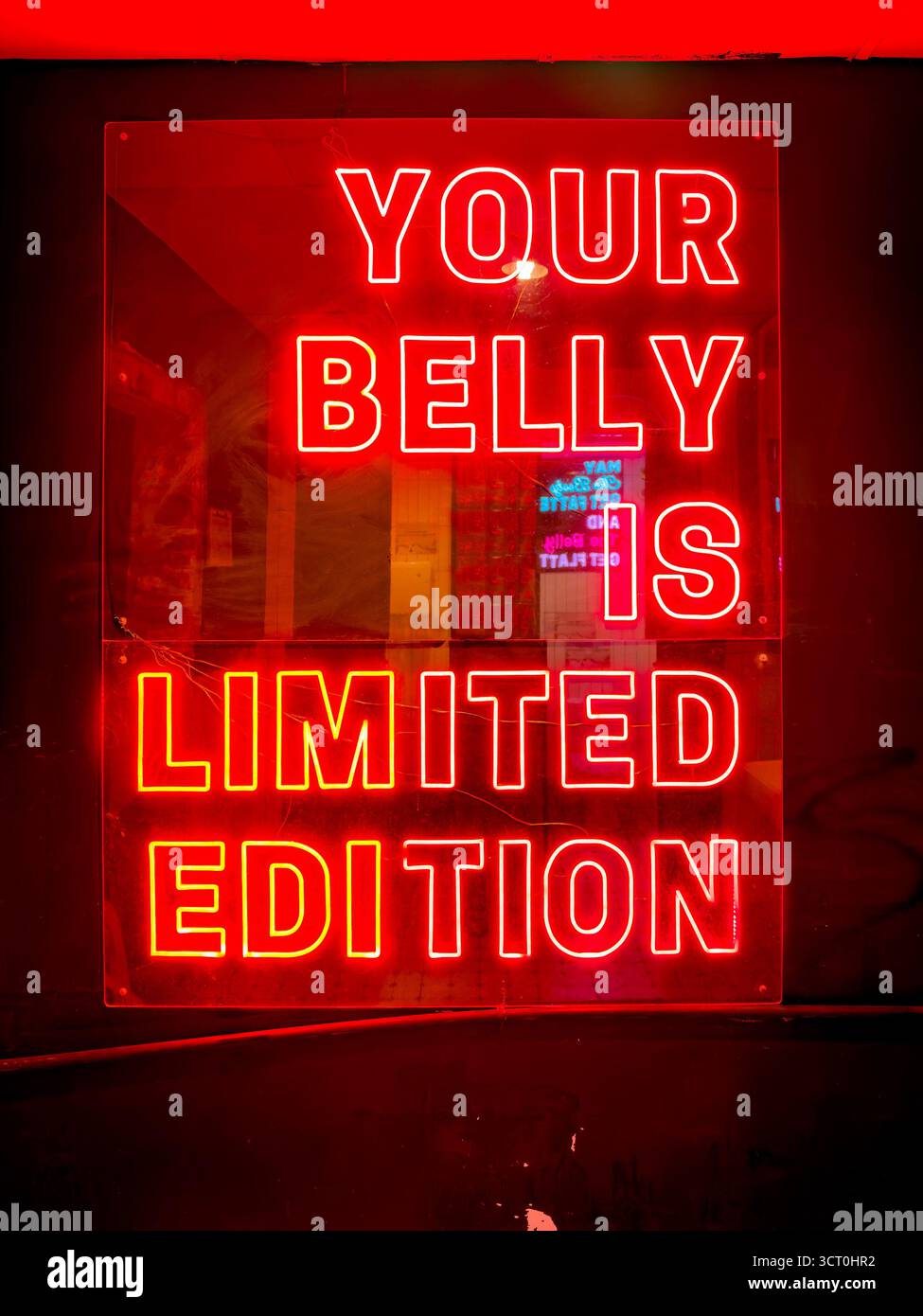 neon sign 'your belly is Limited Edition ' in bold capital letters restroom toilets of restaurant   ipoh malaysia - Smartphone Captured Stock Image