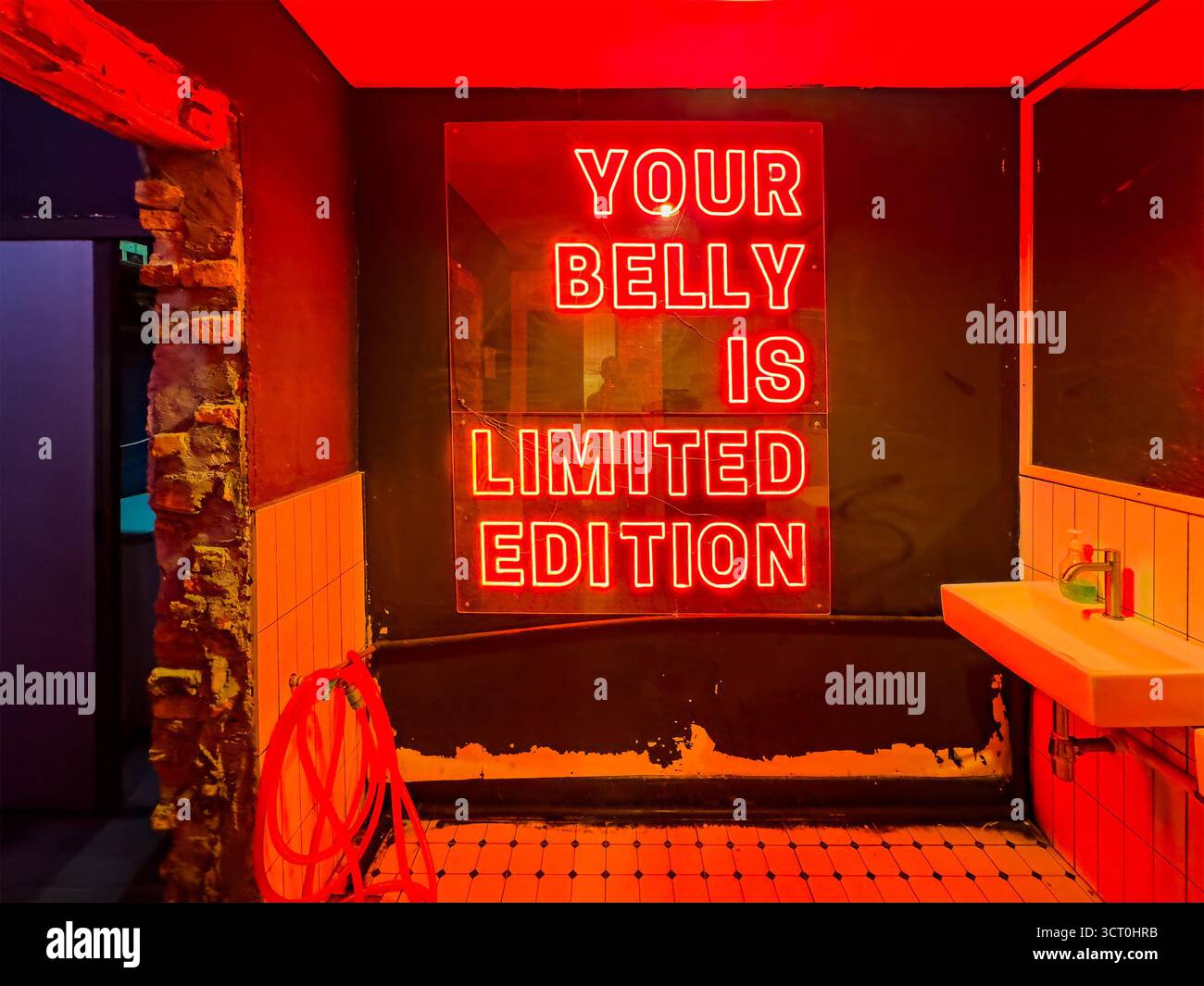 neon sign 'your belly is Limited Edition ' in bold capital letters restroom toilets of restaurant   ipoh malaysia - Smartphone Captured Stock Image