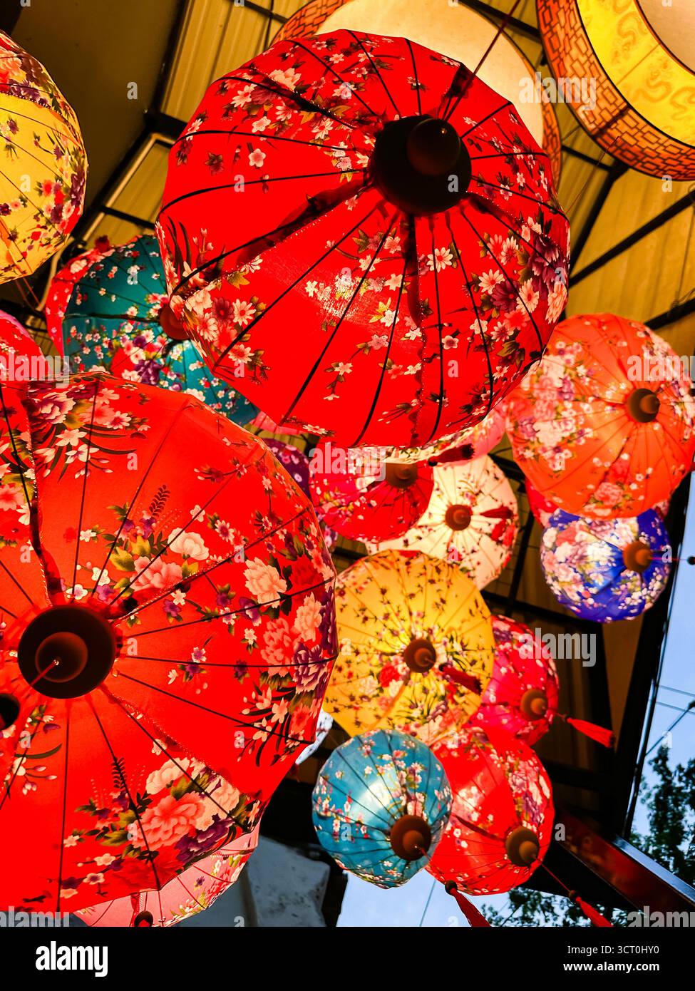 Colorful array of traditional Asian paper lanterns with floral patterns hanging from a ceiling showcasing cultural decoration ipoh malaysia - Smartphone Captured Stock Image
