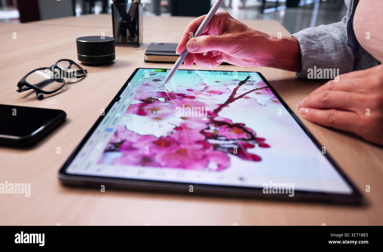 Creative Designer Editing Digital Artwork On Tablet At Desk Stock Photo