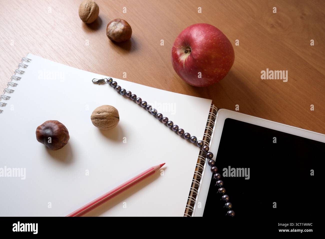 Writing tools and fruits arranged on a wooden table inspire creativity. Stock Photo