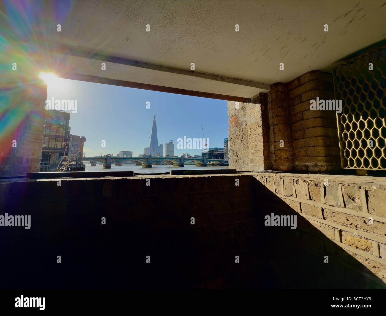 The Shard and Southwark bridge from Queenhithe Dock with lens flare from the early morning sun, City of London - Smartphone Captured Stock Image