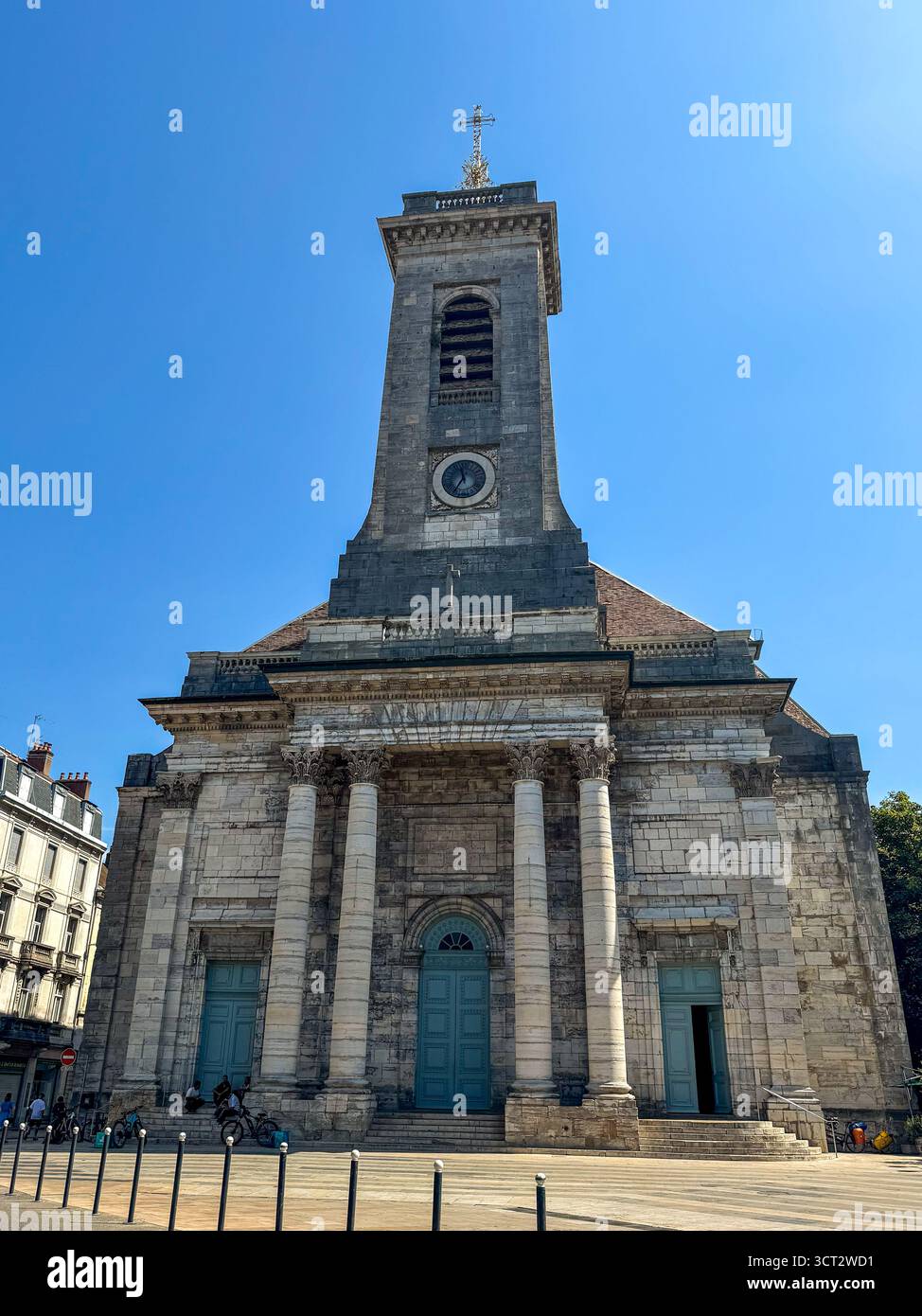 close view of Saint-Pierre Church in Besançon, France, featuring a neoclassical stone facade, blue doors and a bell tower under a clear sky. - Smartphone Captured Stock Image