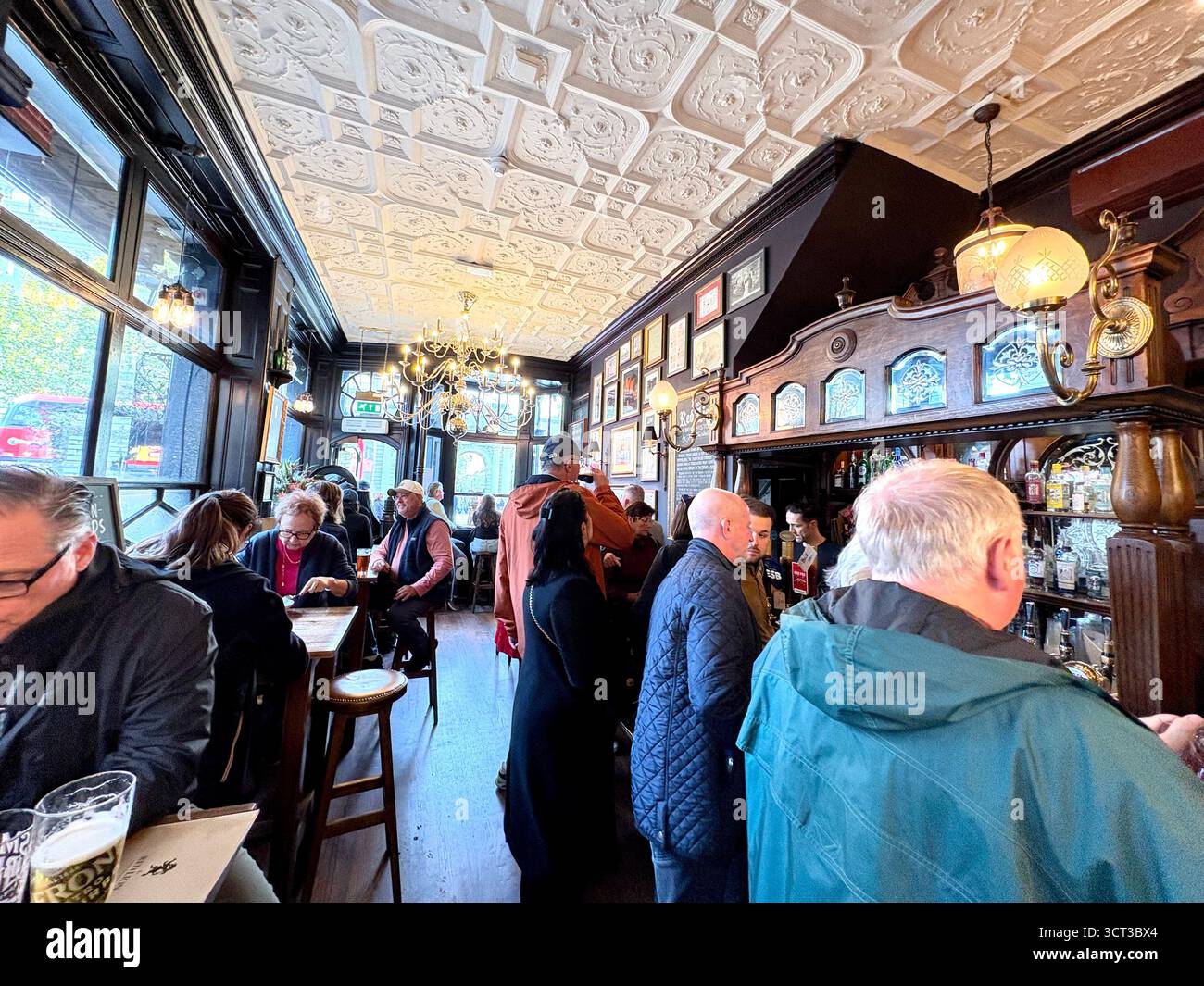 Red Lion pub London England, customers enjoying a pint and lunch inside this famous Whitehall pub, UK - Smartphone Captured Stock Image