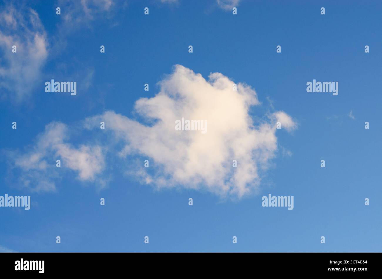 Single Fluffy White Cloud Floating in a Clear Vivid Blue Sky Stock Photo