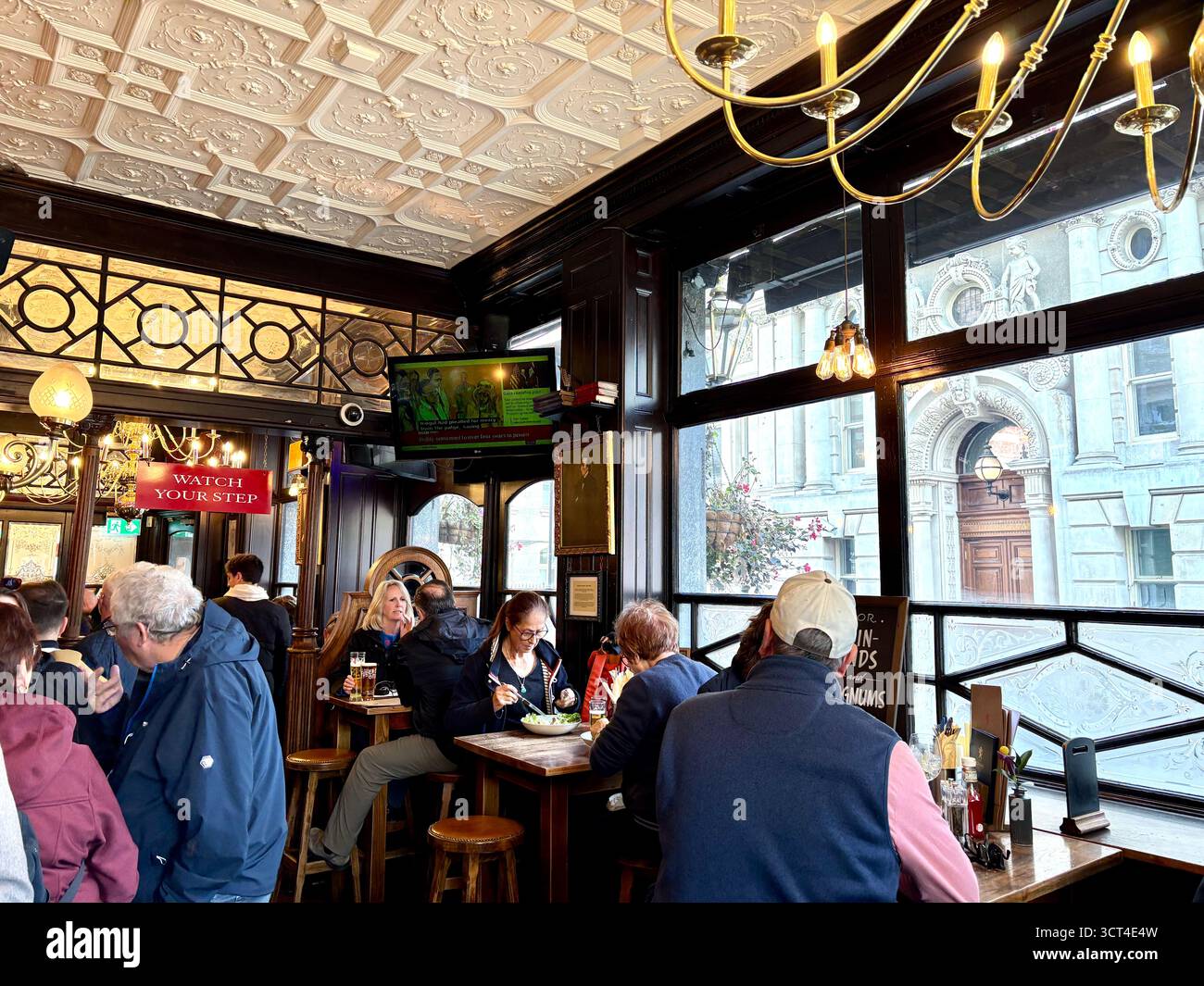 The Red Lion pub, Parliament street,Whitehall, London,England, pub interior people drinking and having lunch - Smartphone Captured Stock Image