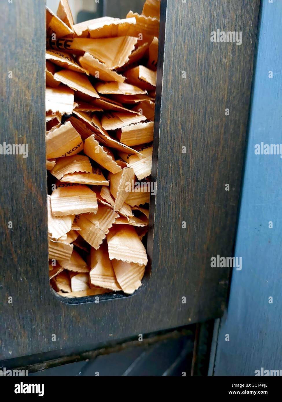 Coffee vendors use sugar sticks from a wooden dispenser to sweeten street coffee for customers enjoying their drinks in the lively city atmosphere. Stock Photo