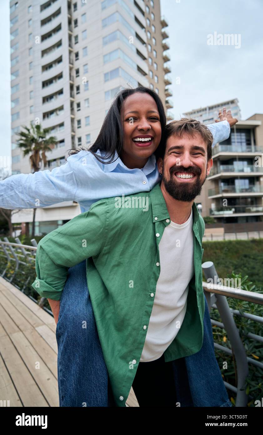Interracial couple piggybacking and having fun in the city Stock Photo