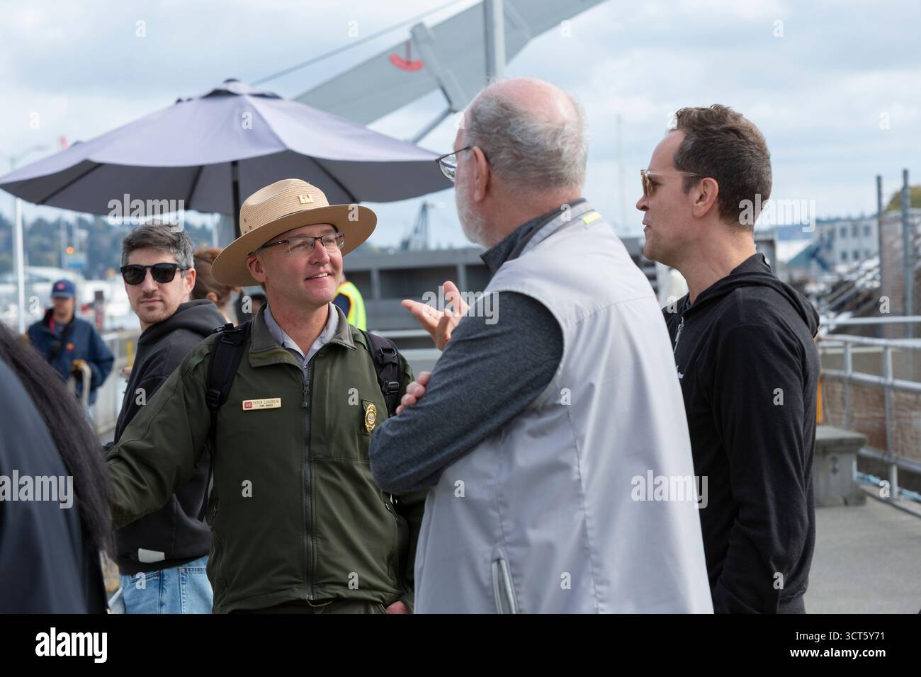 Seattle, Washington, USA. 4th October 2025. Park Ranger Peter Lundberg speaks with visitors at the Hiram M. Chittenden Locks. The Ballard Locks, as they are known locally, are a popular tourist attraction operated by the United States Army Corps of Engineers. Though currently open the public during the government shutdown, the site’s visitor center, gardens and park rangers are present funded with appropriations for the next two weeks. Credit: Paul Christian Gordon/Alamy Live News Stock Photo