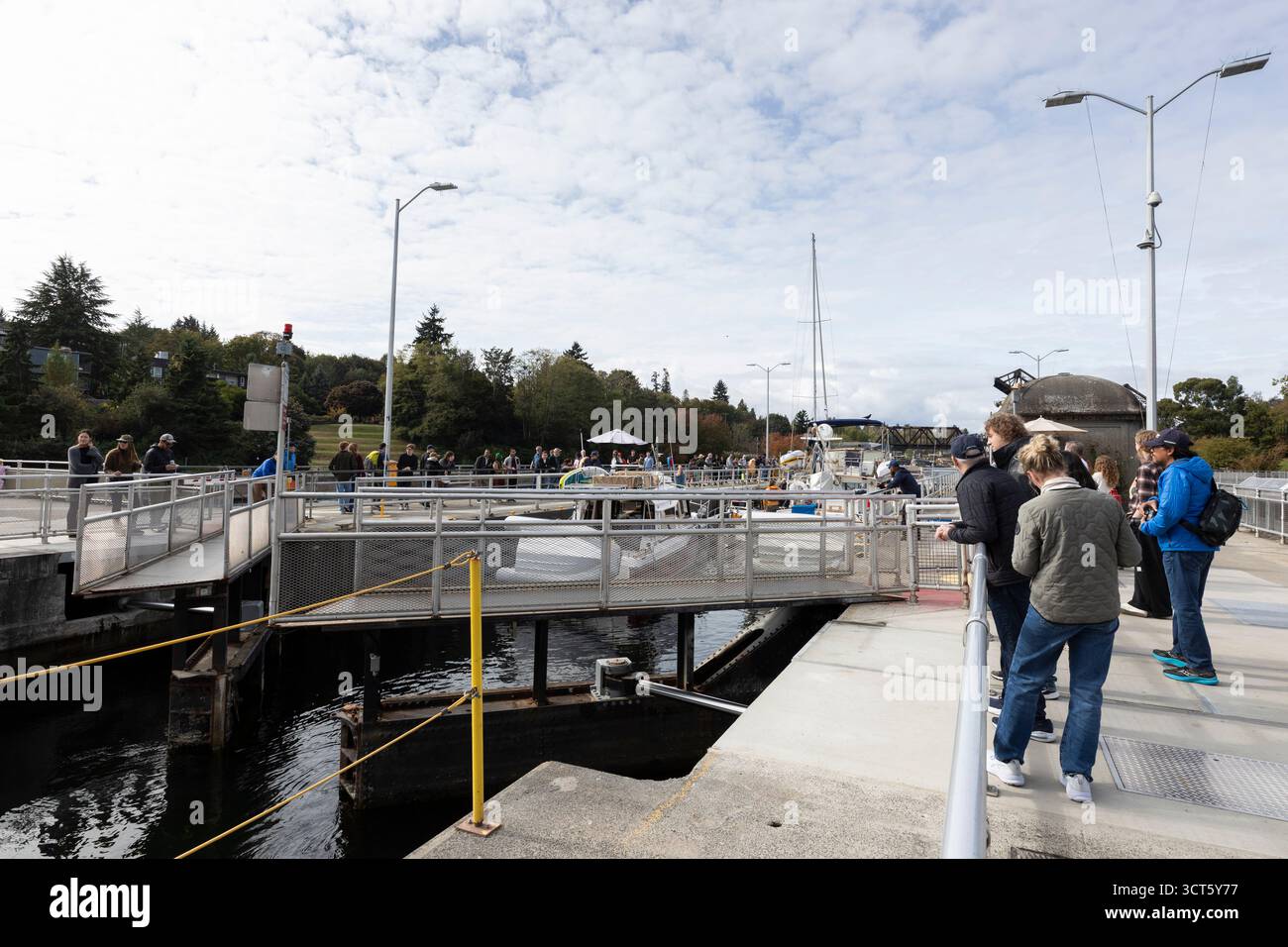 Seattle, Washington, USA. 4th October 2025. Visitors watch a gate close at the Hiram M. Chittenden Locks. The Ballard Locks, as they are known locally, are a popular tourist attraction operated by the United States Army Corps of Engineers. Though currently open the public during the government shutdown, the site’s visitor center, gardens and park rangers are at present funded with appropriations for the next two weeks. Credit: Paul Christian Gordon/Alamy Live News Stock Photo