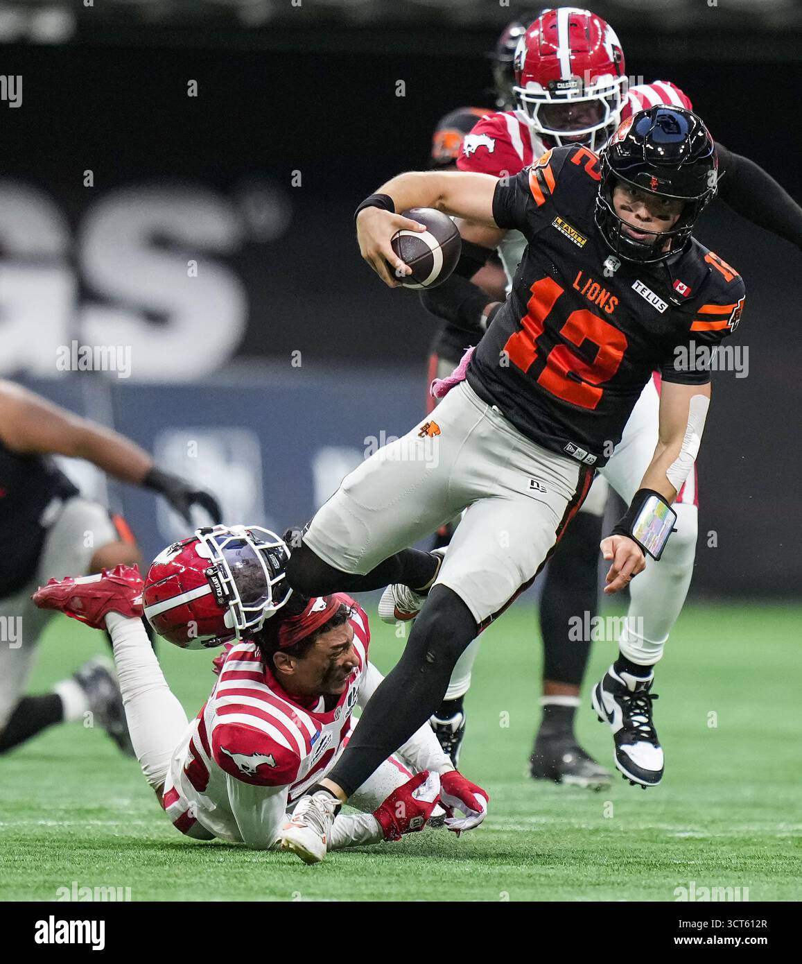 B.C. Lions quarterback Nathan Rourke, front right, gets away from ...