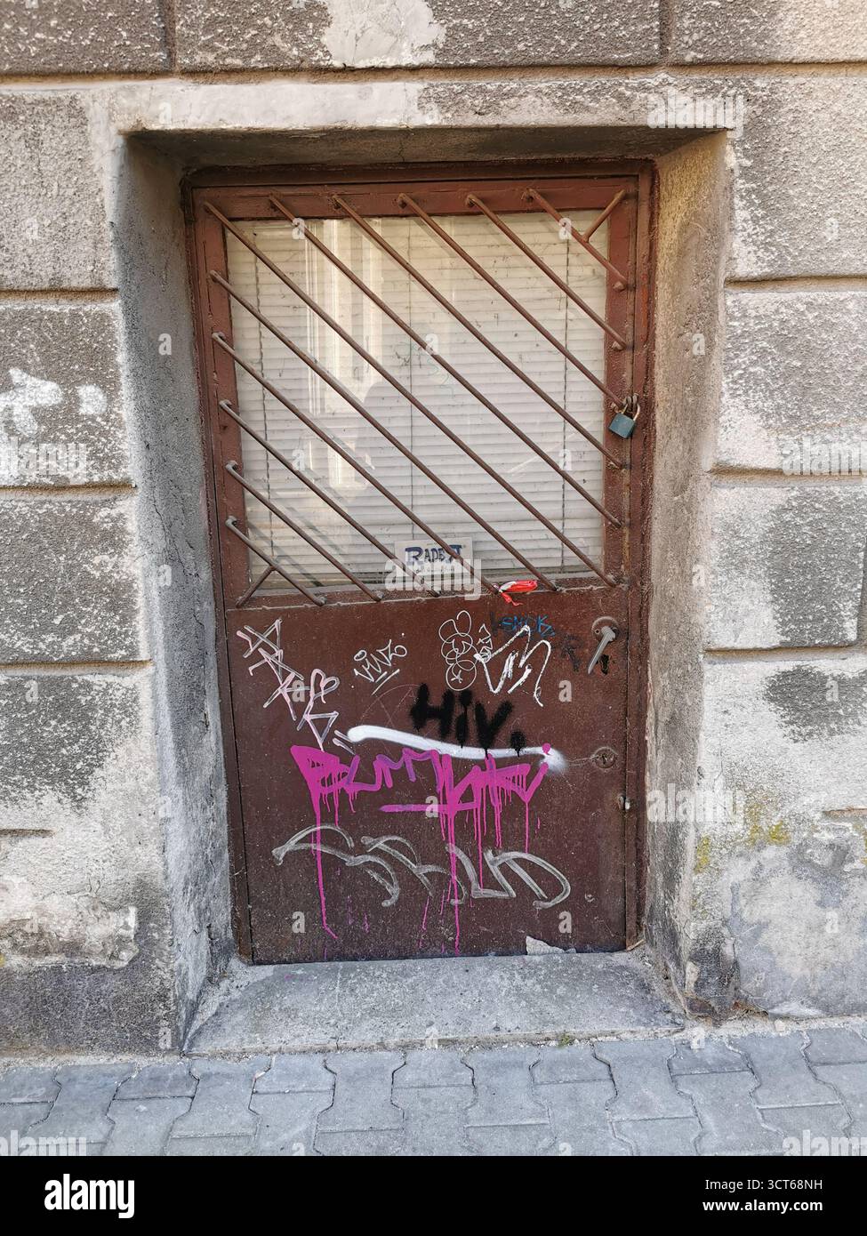 Tiny door on Ulica Rękawka, Kraków—used when main Parkowa entrance was bricked up—marks Roman Polanski’s wartime home in the Kraków Ghetto, Podgórze. - Smartphone Captured Stock Image