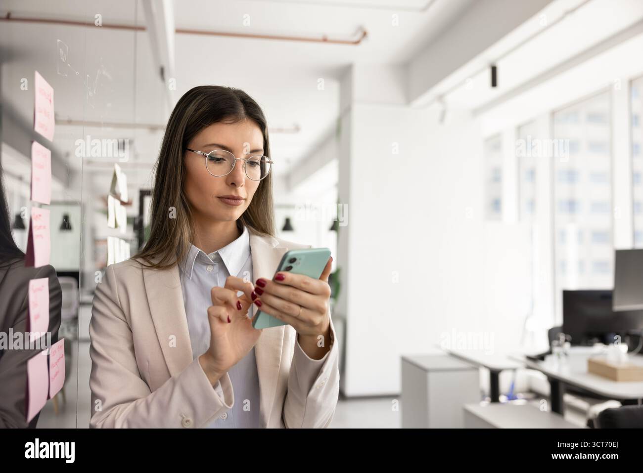 Serious busy project manager using online business application on smartphone Stock Photo