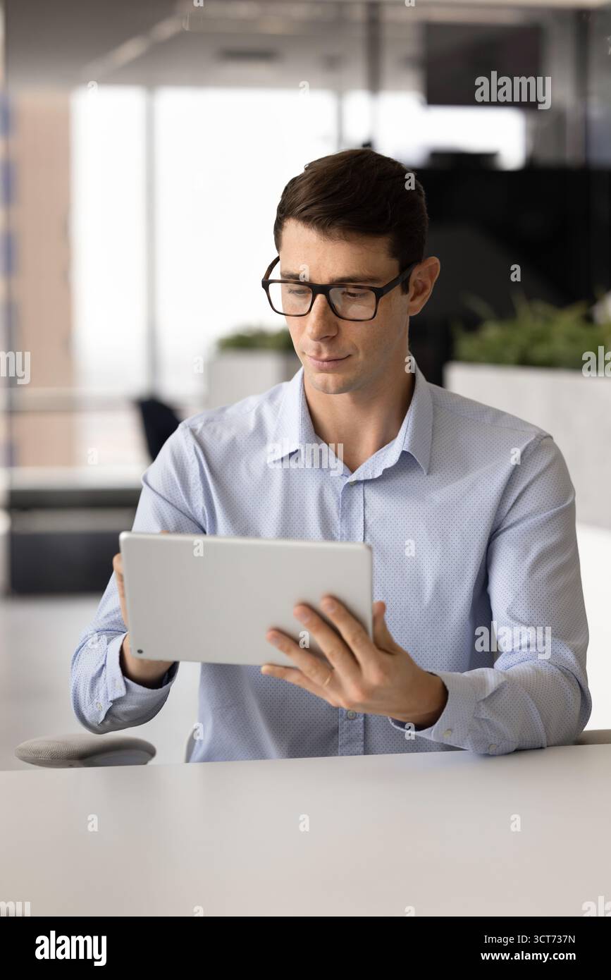 Serious smart Latin project manager man using professional software Stock Photo
