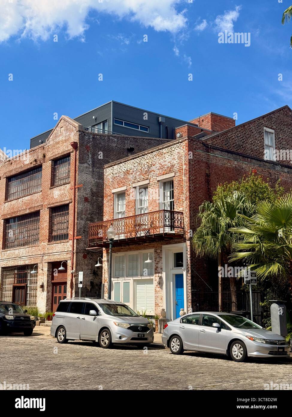 Cobbled street and historic brick buildings under dramatic clouds, New Orleans - Smartphone Captured Stock Image