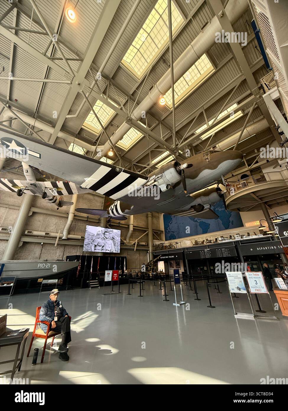 Industrial interior of a large building with high ceilings, exposed metal beams, ductwork and hanging lights, possibly a factory or warehouse space in - Smartphone Captured Stock Image