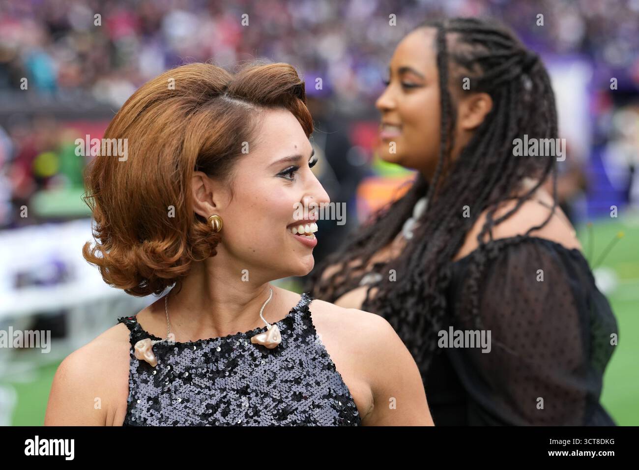 Raye stands on the field during halftime at an NFL football game ...