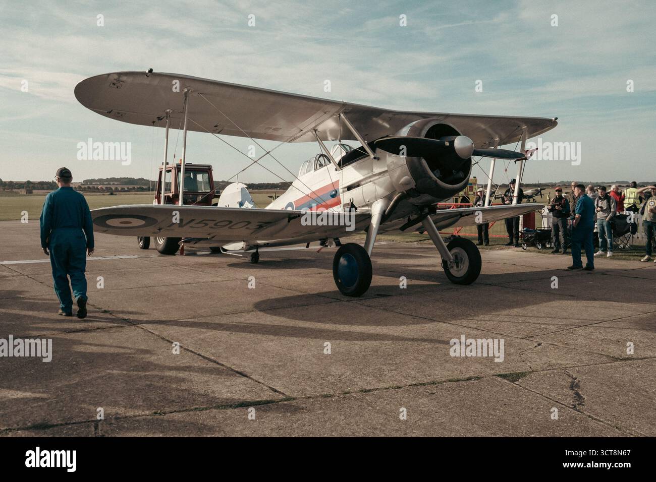 Vintage biplane aircraft on display at Duxford airfield with visitors ...