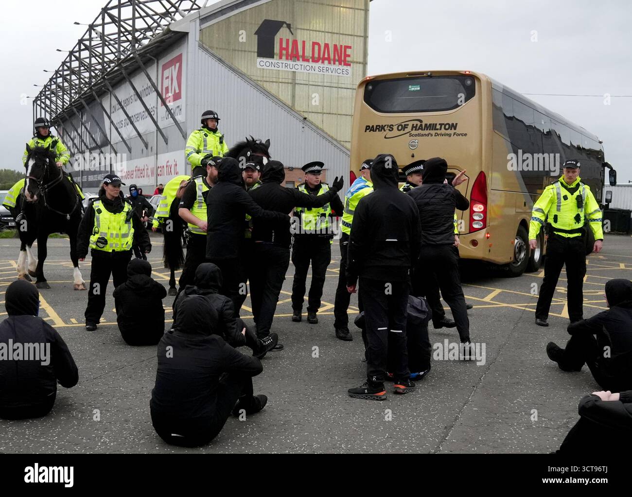Police officers look on as Rangers fans are sat in the car park as the ...