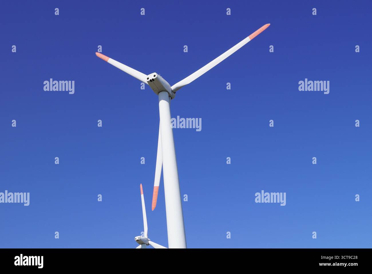 Wind turbines spinning against a clear blue sky in a renewable energy ...
