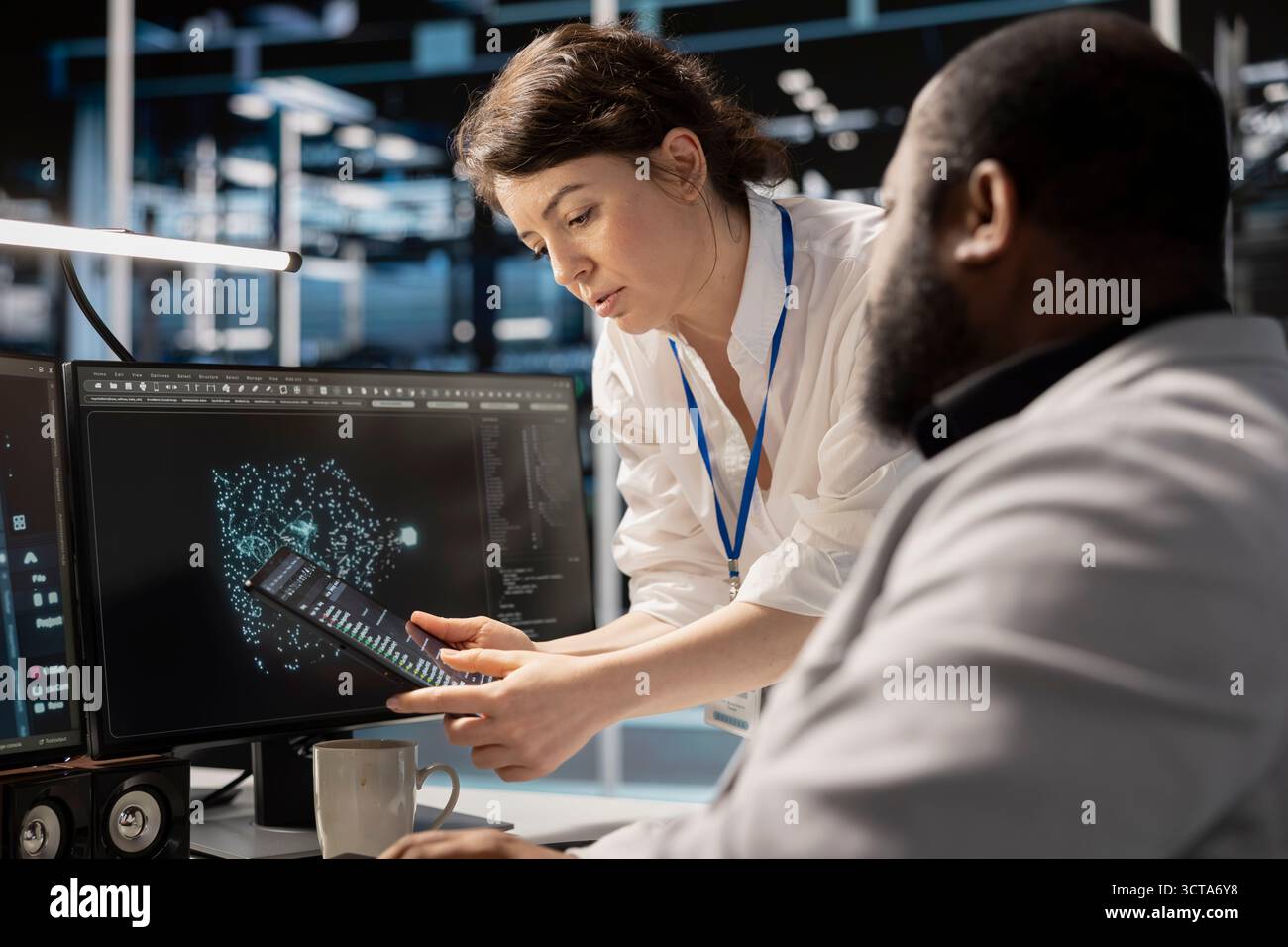 Data center engineers collaborating, doing brainstorming, analyzing software logs to optimize storage systems. Server farm teamworking colleagues inspecting resource utilization on device Stock Photo