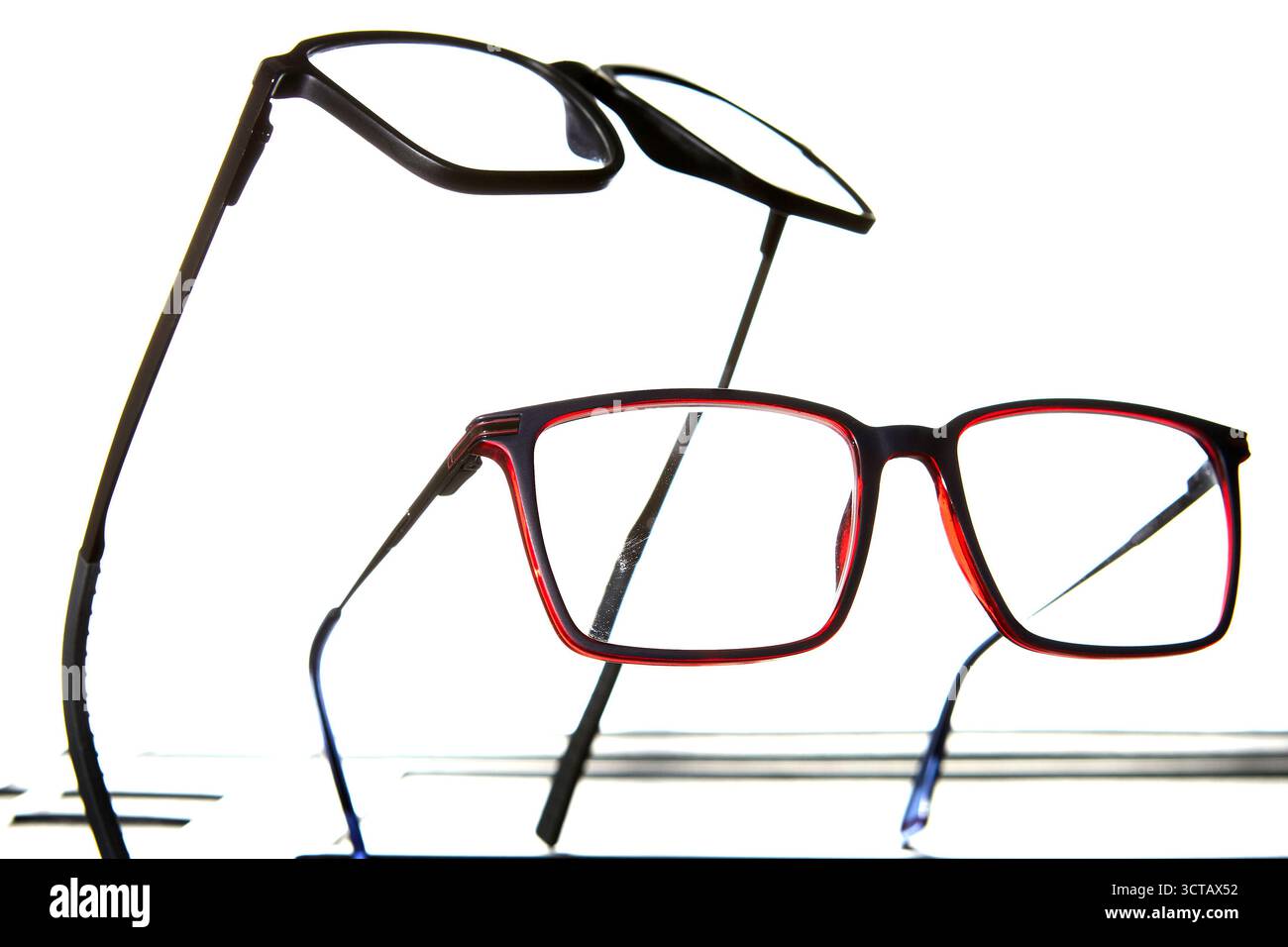 Studio photo showing two eyeglasses with different colors isolated on white background, concept of optical care, fashion accessory and vision correcti Stock Photo