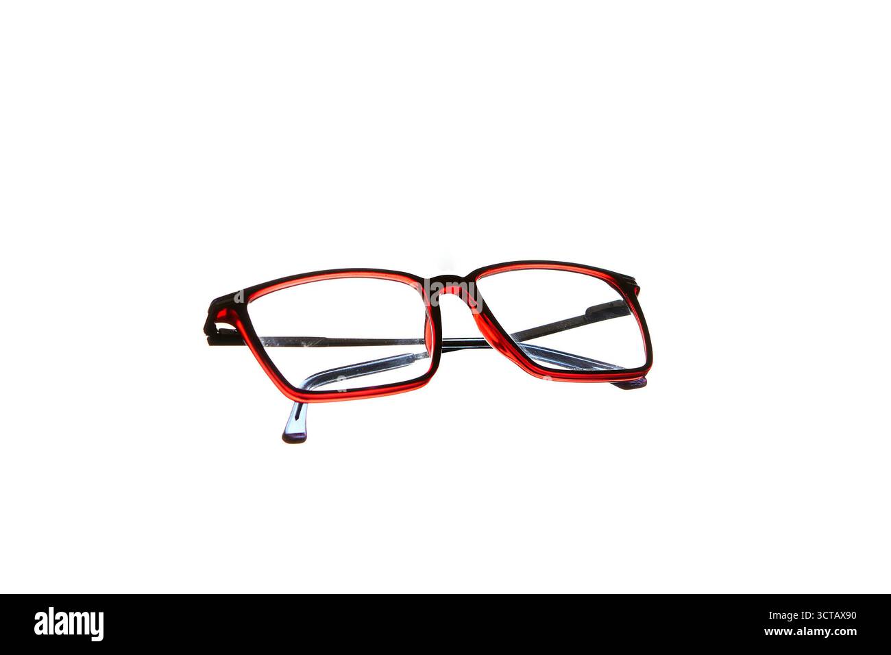 Closeup of red eyeglasses isolated on white background in frontal view showing lens detail and stylish optical fashion accessory concept. Stock Photo