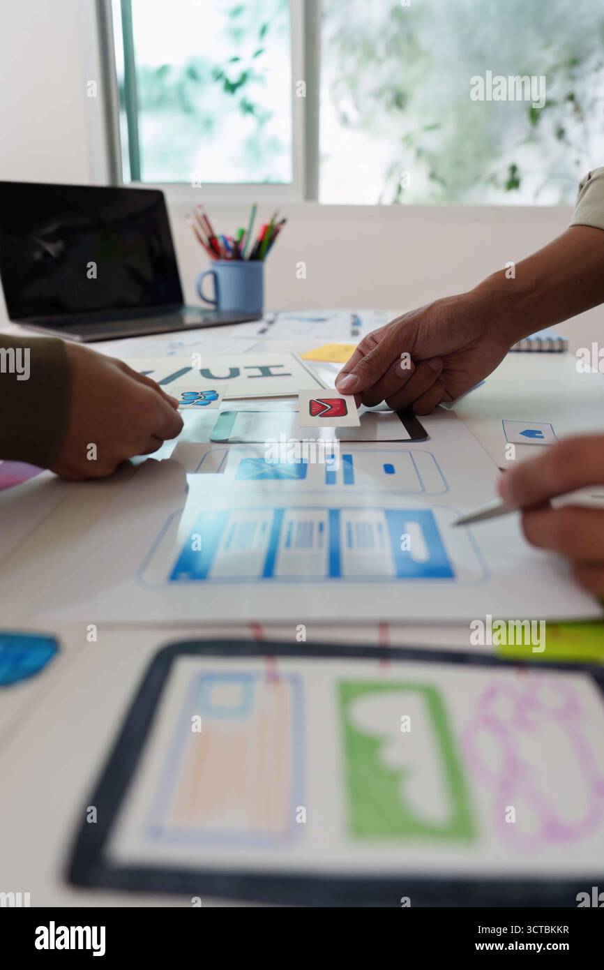 Collaborative UX UI Design Process. Team discussing wireframes and user interface layouts. Stock Photo