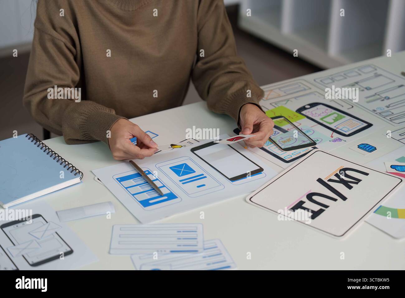 UX UI Design Process. Designer Creating Mobile App Wireframes and User Interfaces. Stock Photo