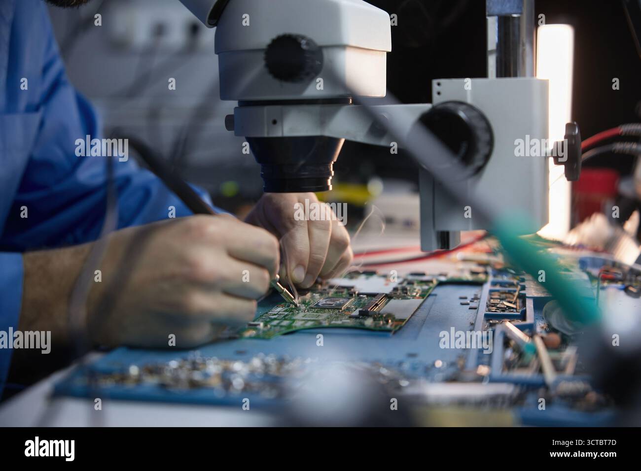 Technician repairing circuit board under microscope Stock Photo