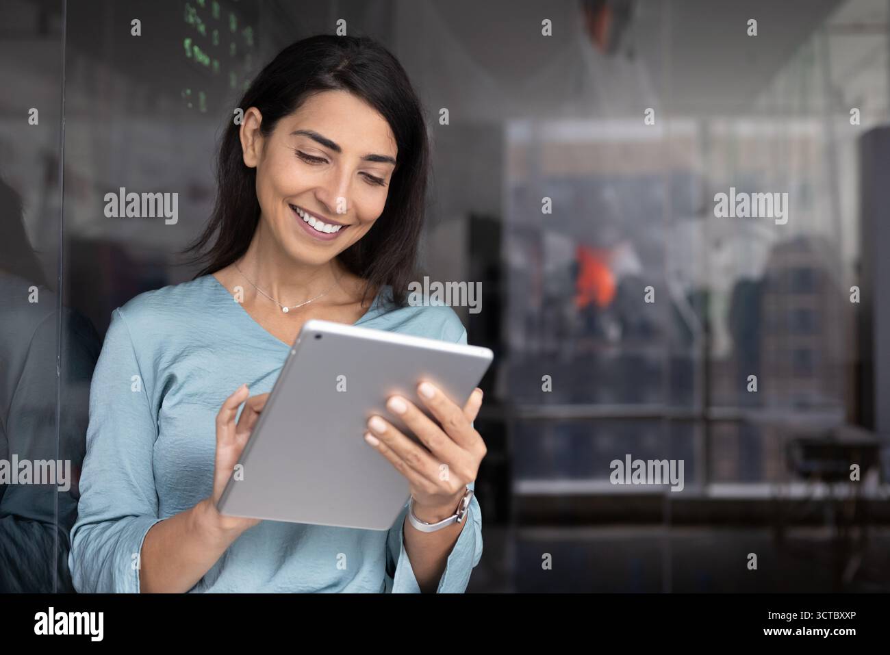 Positive young Latin coach woman using tablet Stock Photo