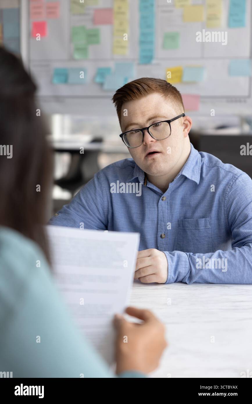 Serious professional man with Down syndrome talking to employer Stock Photo