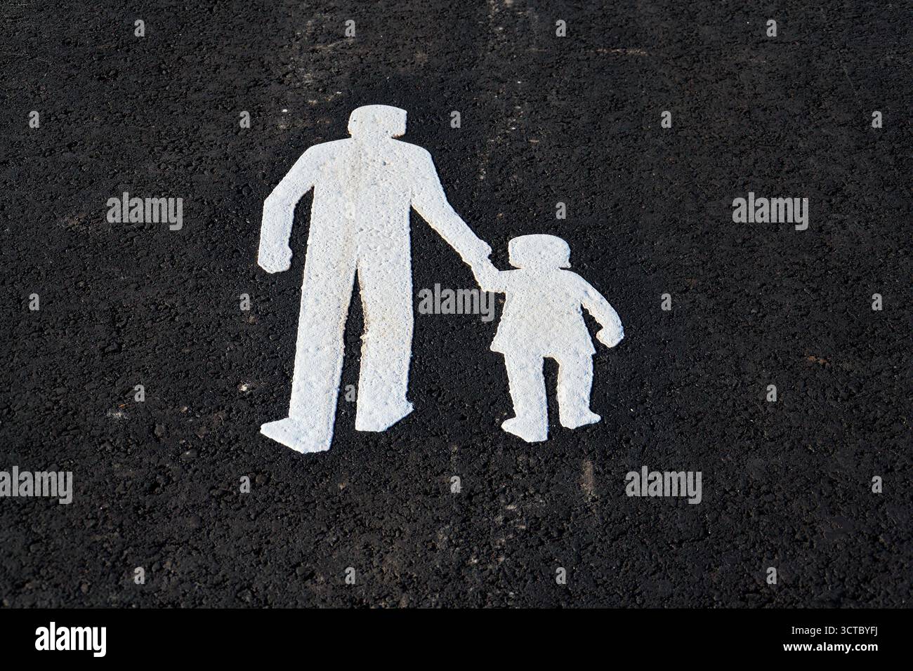 Sidewalk sign depicting walking adult holding a childs hand on the