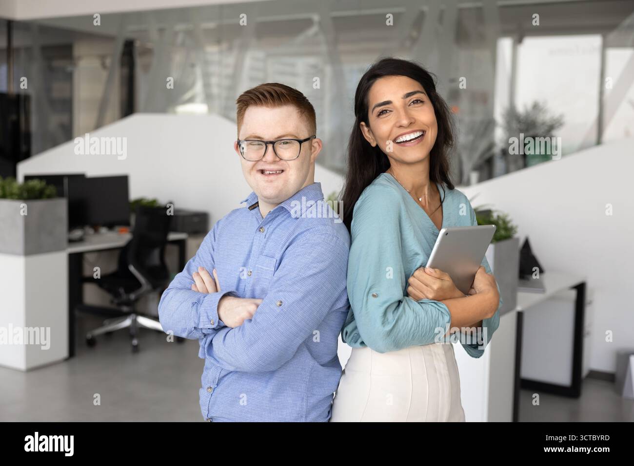 Two cheerful diverse colleagues posing together, standing close Stock Photo