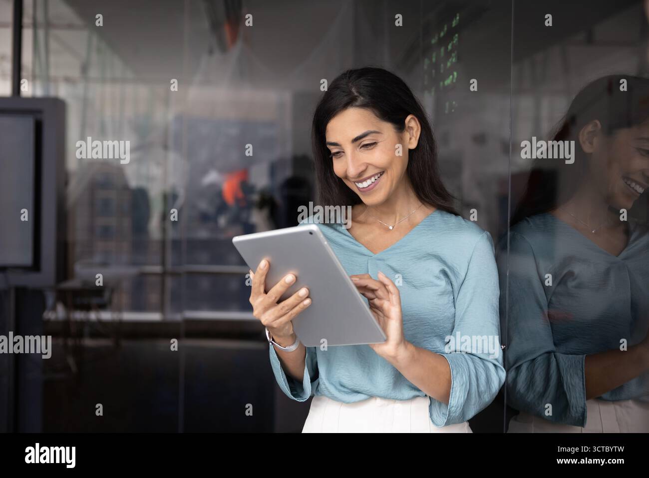 Cheerful Hispanic businesswoman working on successful project Stock Photo