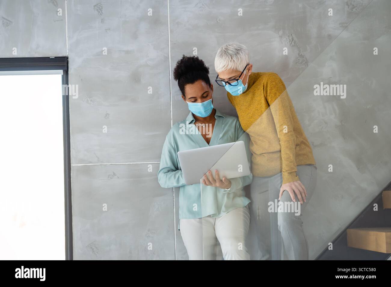Busy business people, programmers software developer engineer working on computer in office in masks Stock Photo