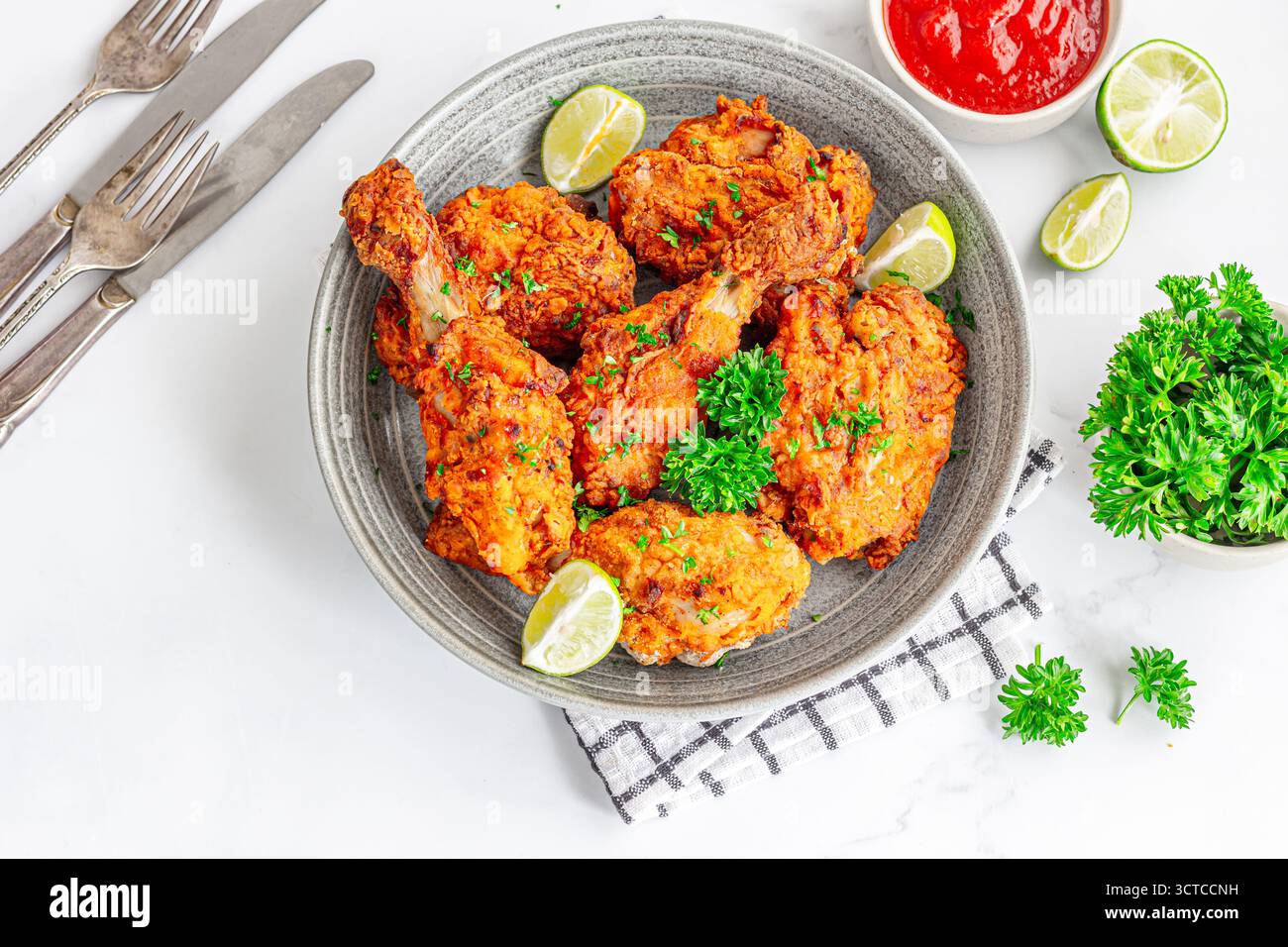 Crispy Fried Chicken Top Down with Ketchup, Lemon and Fresh Parsley Stock Photo