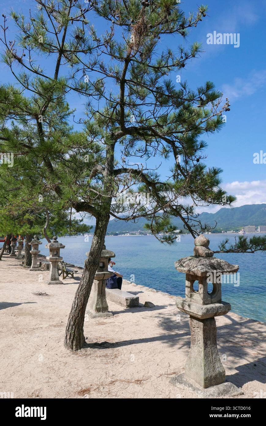 Japan: stone lanterns lining the promenade of the main beach on Miyajima Island (the name often given to Itsukushima Island) located in Hiroshima Bay Stock Photo