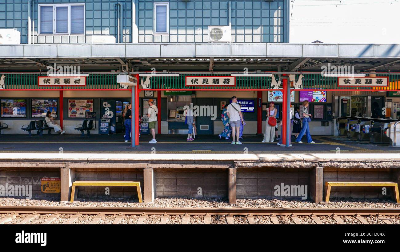 Japan, Kyoto: Passengers and tourists on the platforms of Inari Station in Fushimi Ward, in the southeast of the city. Highly popular with tourists, i Stock Photo