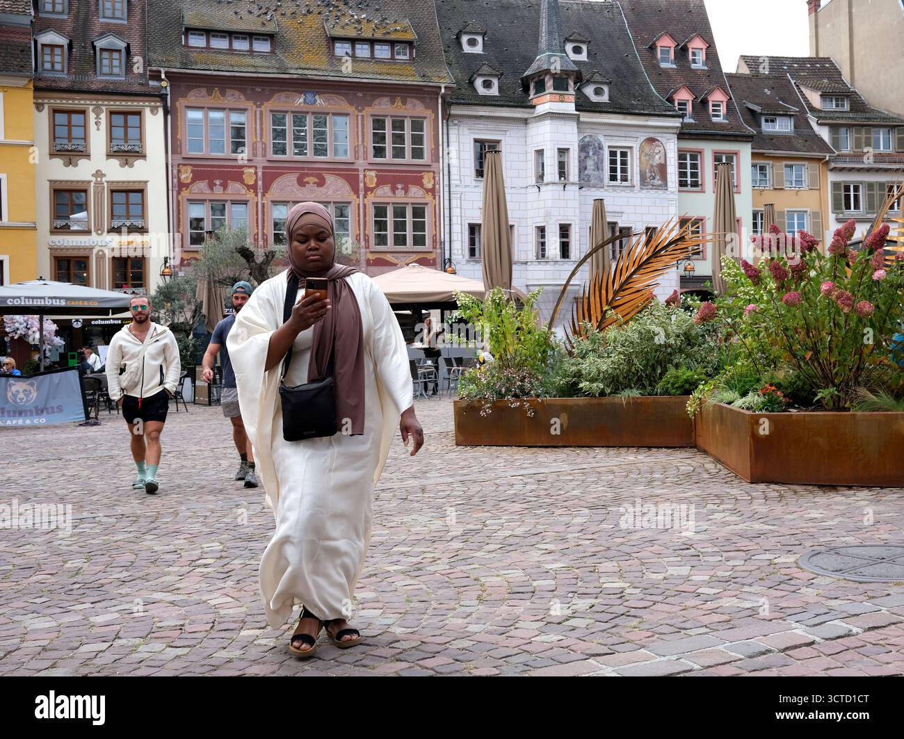 Woman using mobile phone while walking in Mulhouse, France. Stock Photo