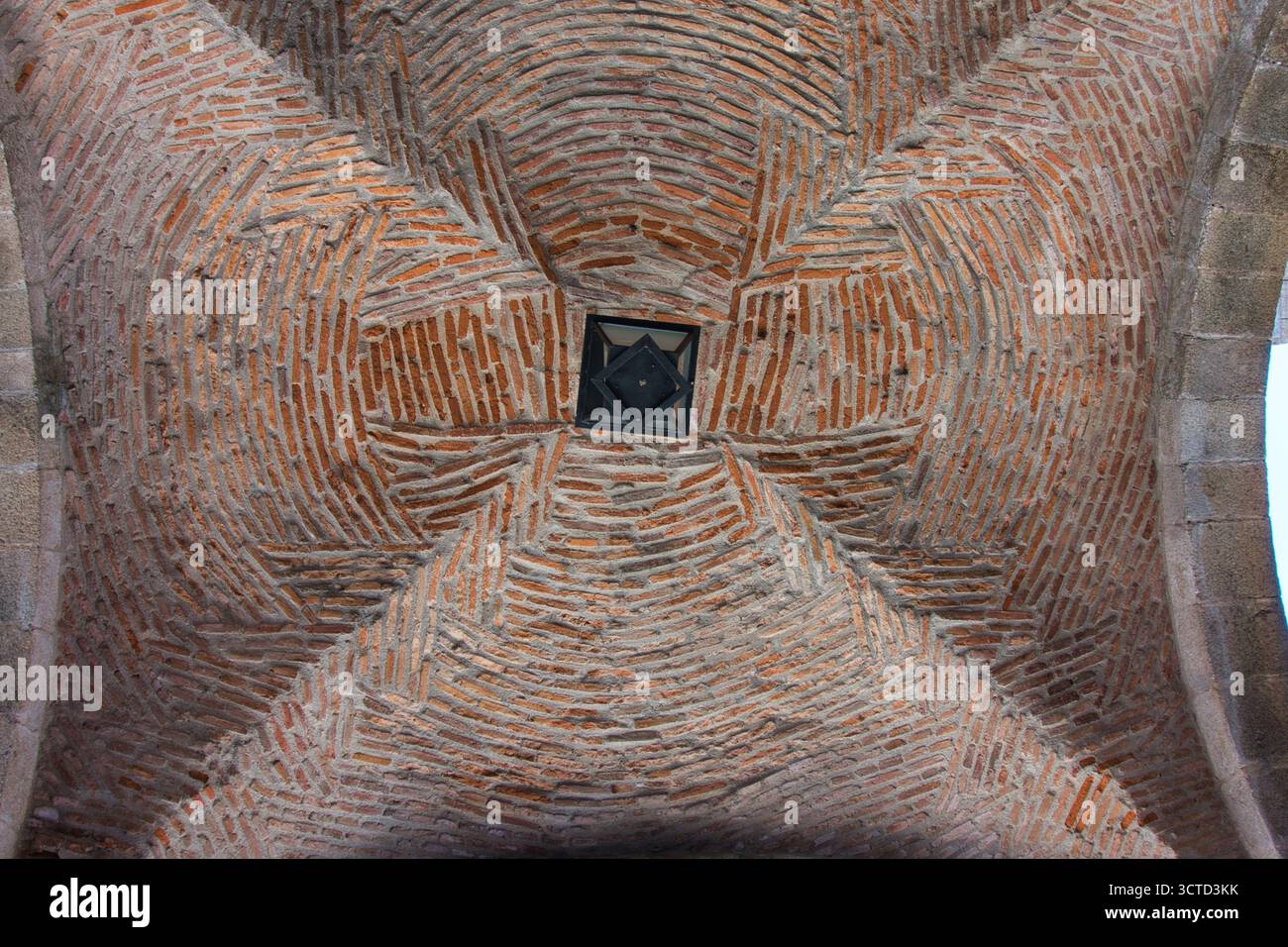 Intricate Brickwork Pattern on Vaulted Ceiling - Close-up, low-angle view of an old architectural ceiling vault featuring a complex, swirling brick pa Stock Photo